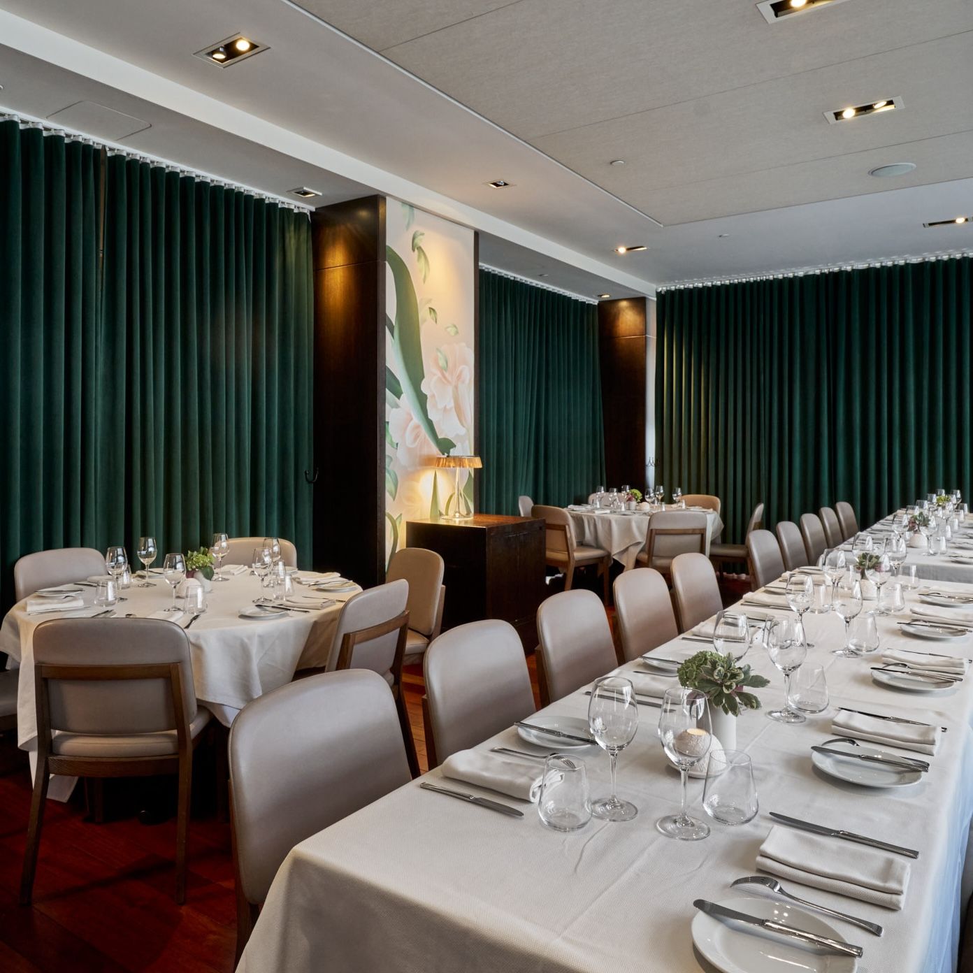 A long rectangular table runs along a banquet with two round tables parallel